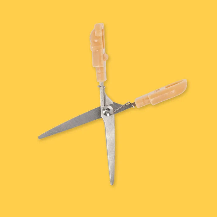 Pair of scissors with beige bear-shaped handles on a yellow background