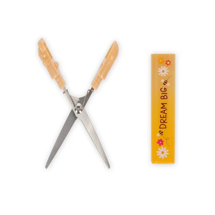 Pair of spring scissors with bear-shaped handles next to a 'Dream Big' branded container on a white background