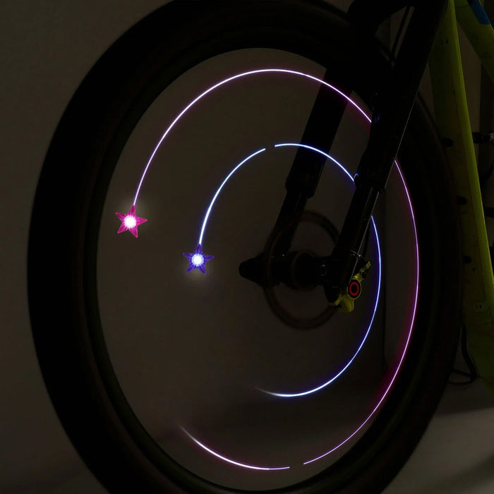 Bicycle wheel with glowing stars in pink and purple lights on a dark background