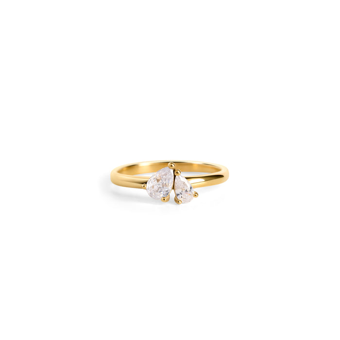 The front of a slim gold ring with two pear-cut clear stones set side by side on a white background. Nickel-free, waterproof & tarnish-resistant stainless steel ring for sensitive skin, minimalist luxury jewelry by Mia Bijoux Canada.

Vue de face d'une bague fine dorée sertie de deux pierres transparentes taille poire côte à côte sur fond blanc. Bague en acier inoxydable sans nickel, résistante à l'eau et anti-ternissement pour peaux sensibles, bijouterie de luxe minimaliste par Mia Bijoux Canada.