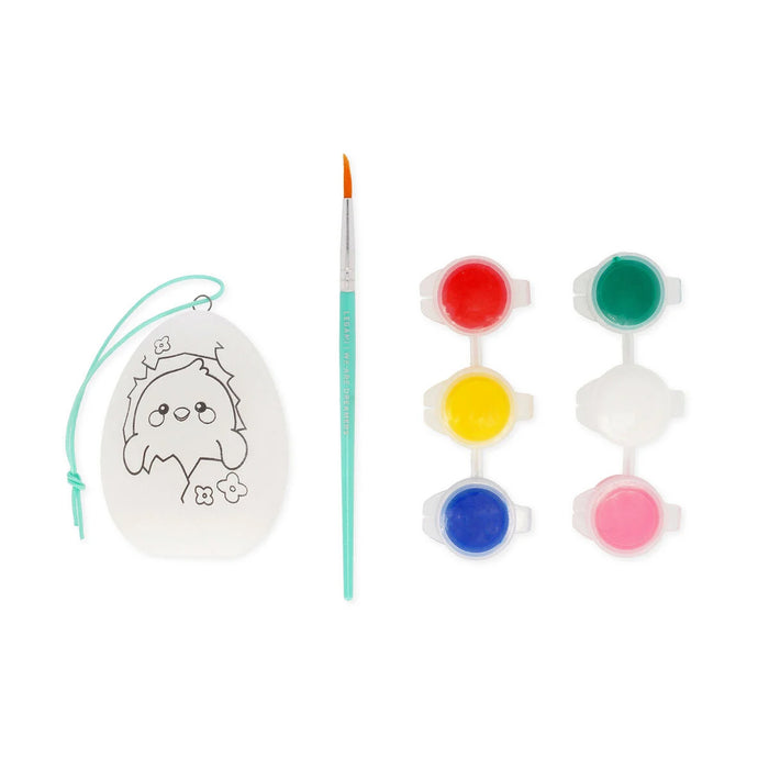 Decorative egg with a design, paintbrush, and color swatches on a white background