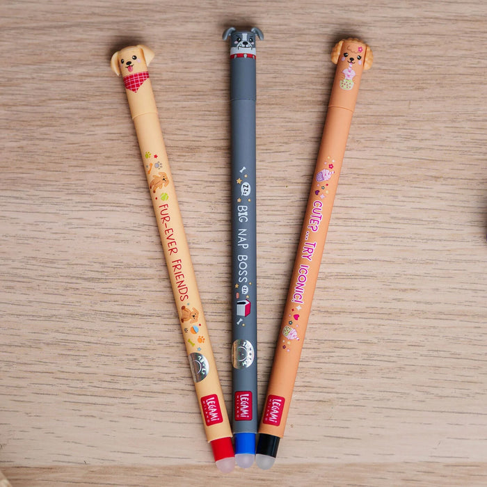 Three erasable gel pens with dog-themed designs on a wooden surface