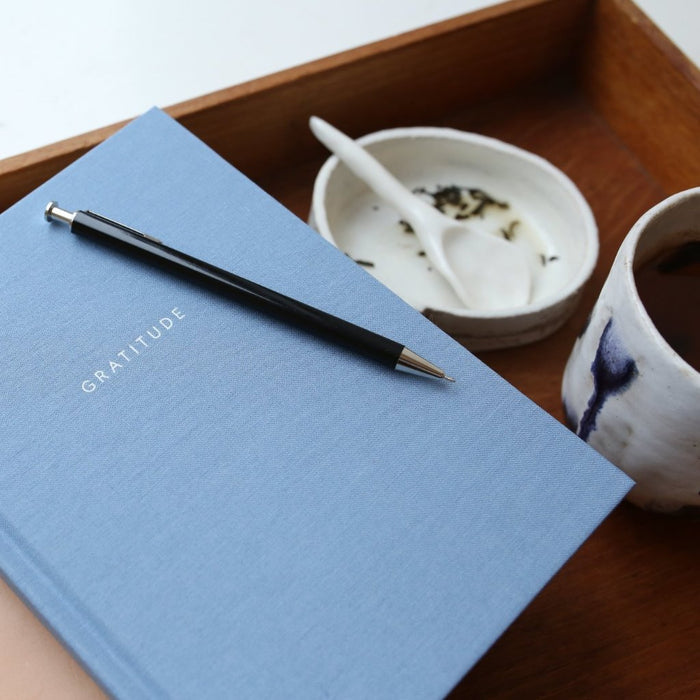 Light blue Gratitude journal on a tray with tea.