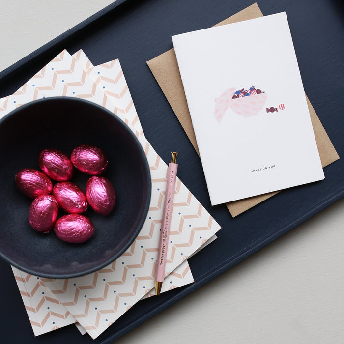 Greeting card with candy bowl and the text 'sweet on you' next to an actual bowl with chocolates.