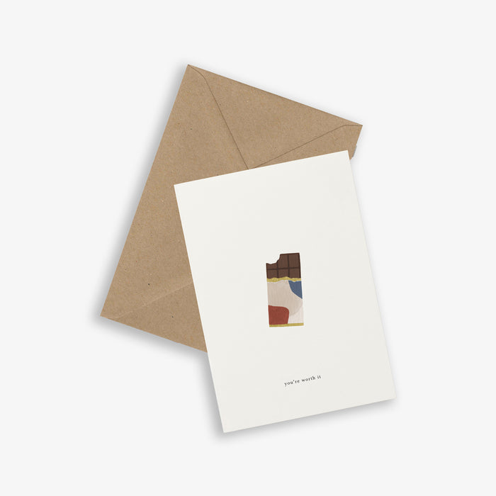 A simple greeting card with an illustrated chocolate bar and the text 'you're worth it', accompanied by a brown kraft envelope.