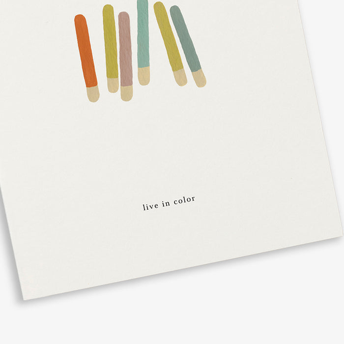 A greeting card with a colorful stick illustration and the phrase 'live in color'.