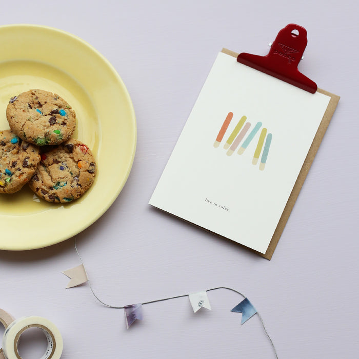 Greeting card with colorsticks and the text 'live in color' and a plate of cookies.