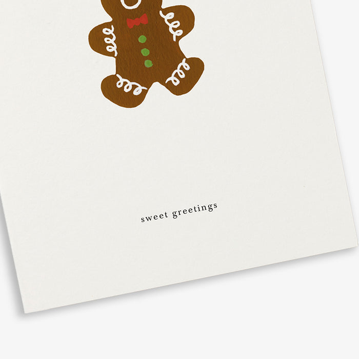 A simple illustrated greeting card with a gingerbread person design. The card is folded and displays the text 'sweet greetings'.