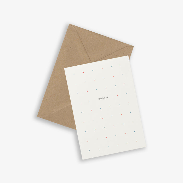 A simple, illustrated greeting card with the text 'HOORAY' on it with dots pattern, accompanied by a brown kraft envelope.
