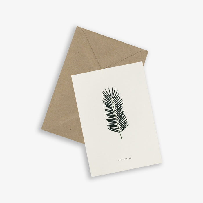 A simple, folded A6 greeting card with a botanical leaf design and the word 'PALM' on it, accompanied by a brown kraft envelope.
