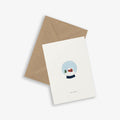 A greeting card with a snowglobe illustration and the text 'let it snow' accompanied by a brown kraft envelope, set against a white background.