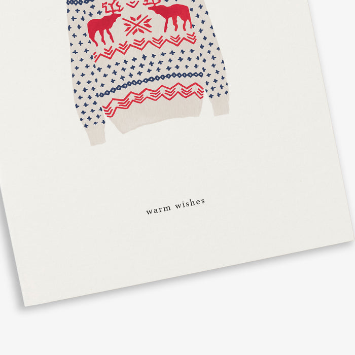 A Christmas-themed greeting card with a sweater pattern and the text 'warm wishes' on it.