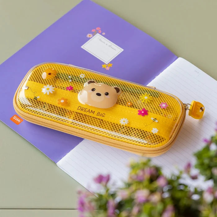 Yellow-ish pencil case with teddy bear design on a purple notebook