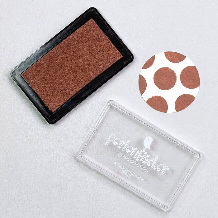 Cinnamon brown ink pad with clear stamp block and polka dot design on a light gray background