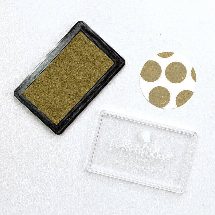 Moos colour ink pad with a clear stamp and gold circle stamps on a white background