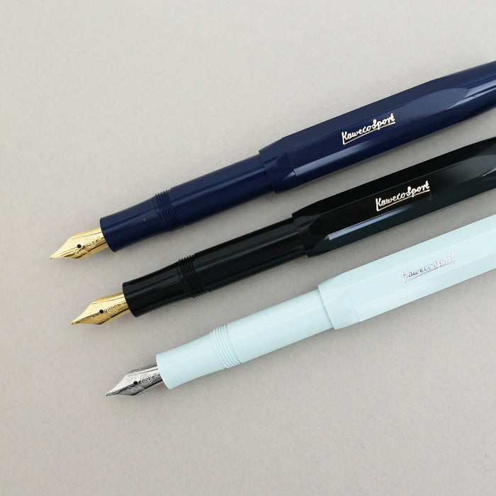 Three Kaweco Classic Sport fountain pen with a gold nib in navy, black and pastel green.