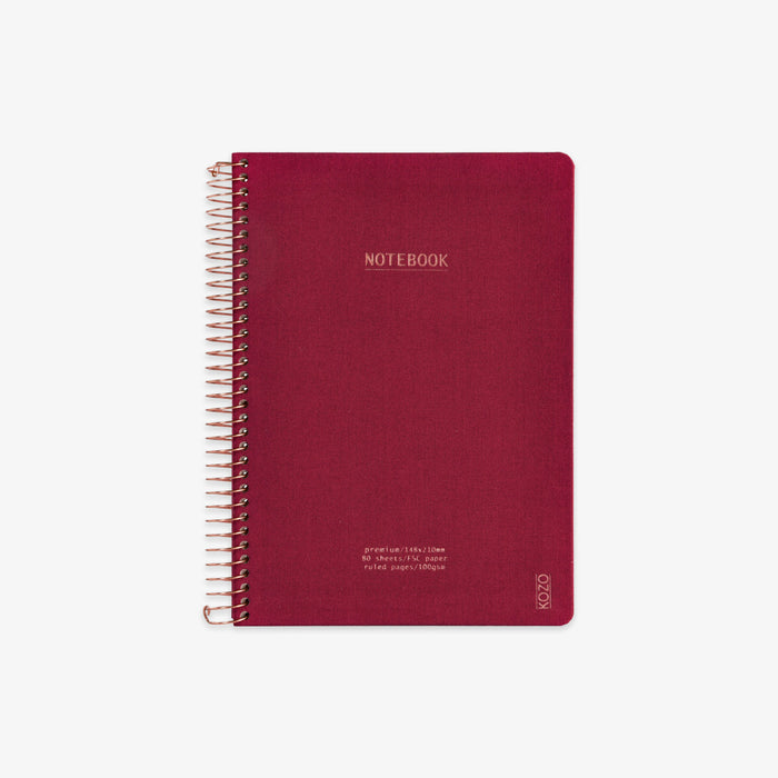 Red notebook with spiral binding on a white background
