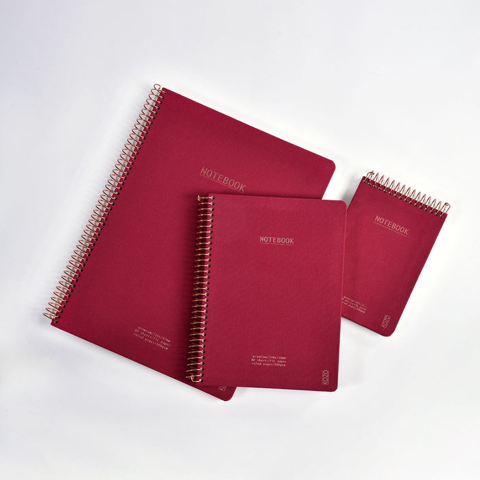 Three red notebooks with spiral binding on a white background