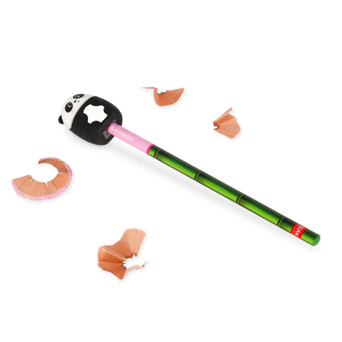 Panda-shaped pencil sharpener with a green pencil and pencil shavings on a white background
