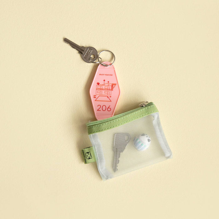 Green mesh pouch with keys in on a beige background