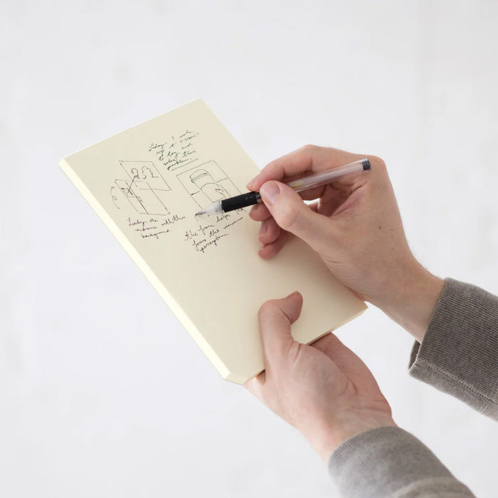 Person writing in a notepad with a pen on a white background