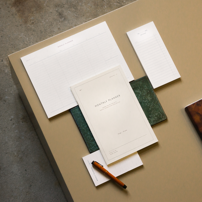 Table set up with an example of how to use the Monthly Planner notebook with other planner notepads.