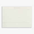 A monthly planner notepad with a grid layout, titled 'MONTHLY PLANNER', on a plain background.