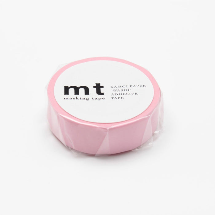 A roll of rose pink masking tape on a white background