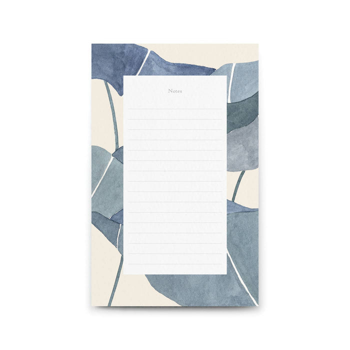 Notepad with blue and beige leaf pattern on a white background