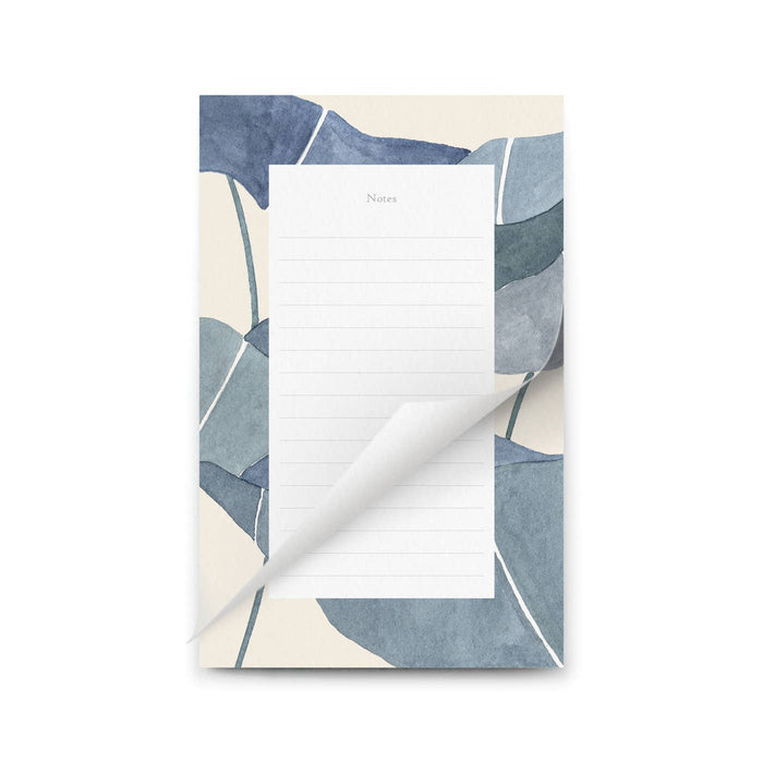 Notepad with a blue and beige abstract leaf pattern on a white background