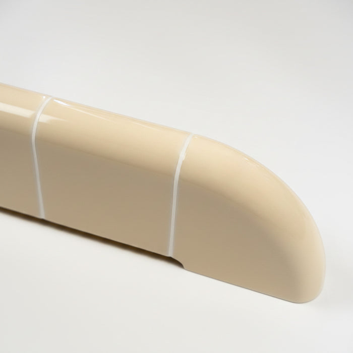 Detail of the Orbi wall shelf in glossy Soft Butter, featuring smooth rounded edges and ceramic-inspired craftsmanship.