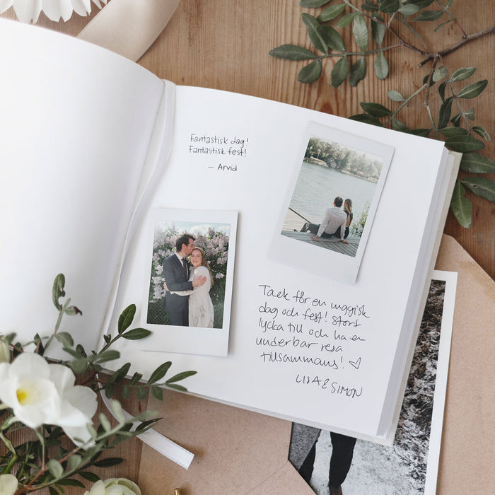 Open guestbook with blank pages and pictures