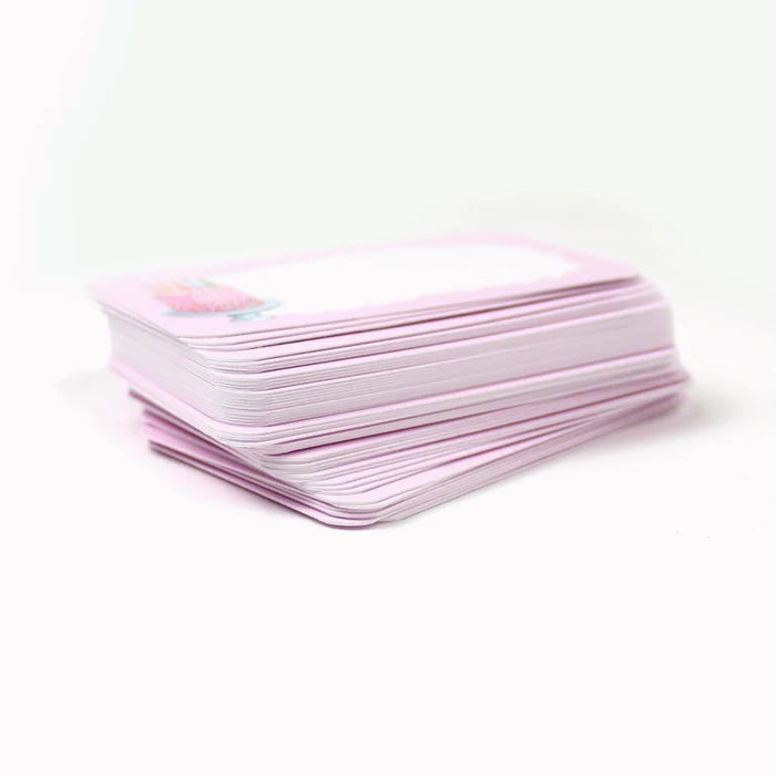 Stack of light pink pocket cards with a birthday cake illustration on a white background