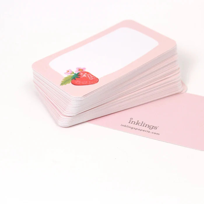 Stack of pink cards with a strawberry illustration on a white background, featuring the brand 'inklings'.