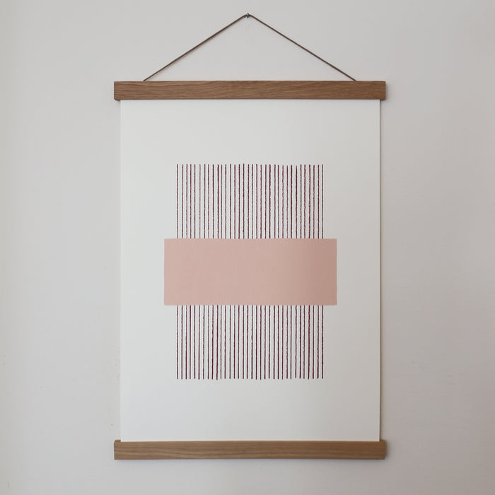 A light pink and white geometric line print framed in an oak frame, with a magnetic closure.