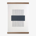A navy and white geometric line print framed in an oak frame, with a magnetic closure.