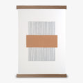 A peach and white geometric line print framed in an oak frame, with a magnetic closure.