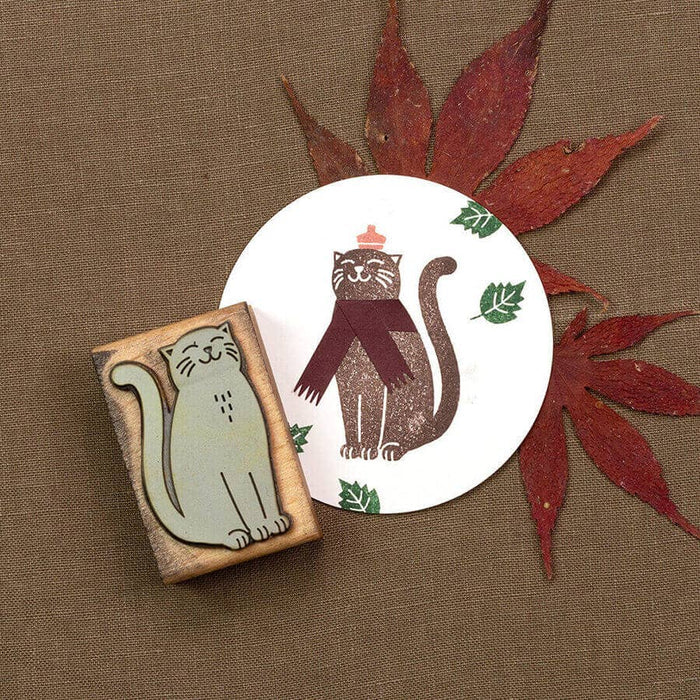 Cat-themed rubber stamp set on a brown background with red leaves