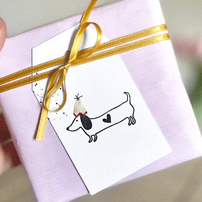 Gift box with a dachshund illustration and gold ribbon