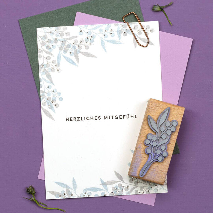 Greeting card with wildberry design and wooden stamp on a purple background