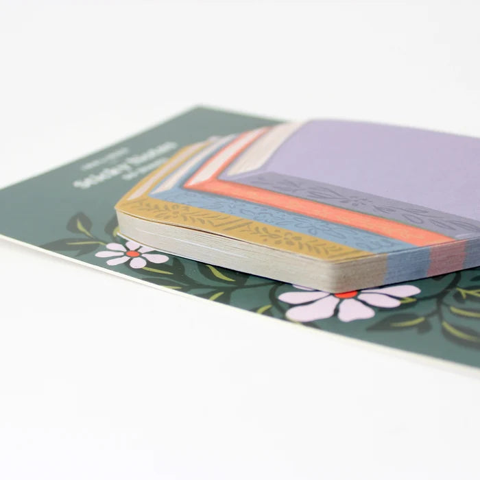 Stack of colorful book stack-shaped sticky notes with floral design on a white background