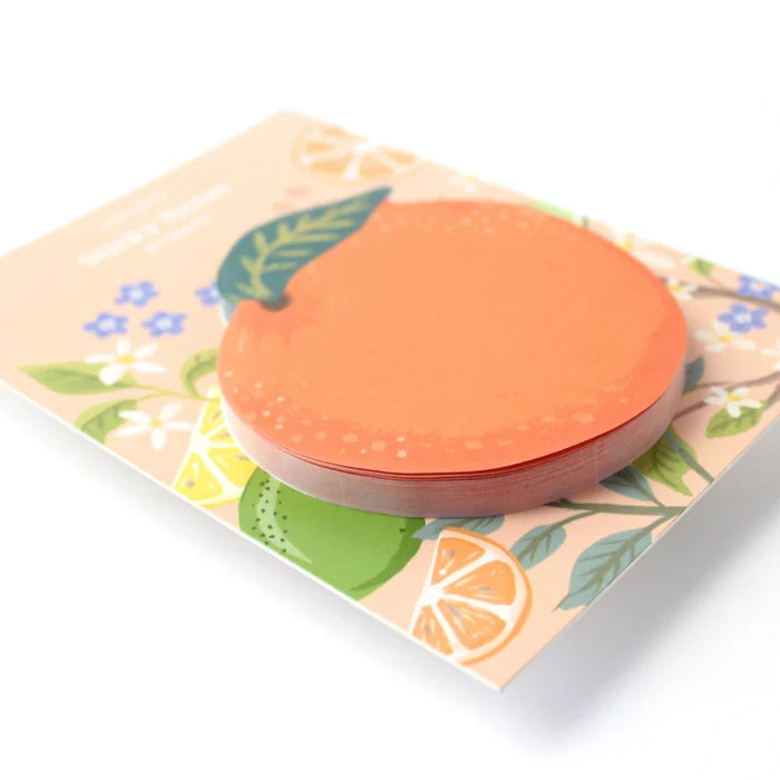 Round orange sticky note on a floral-patterned card