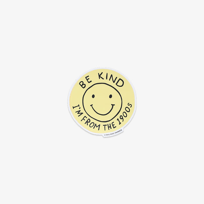 Round yellow sticker with smiley face and text 'Be kind, I'm from the 1900s' on a white background