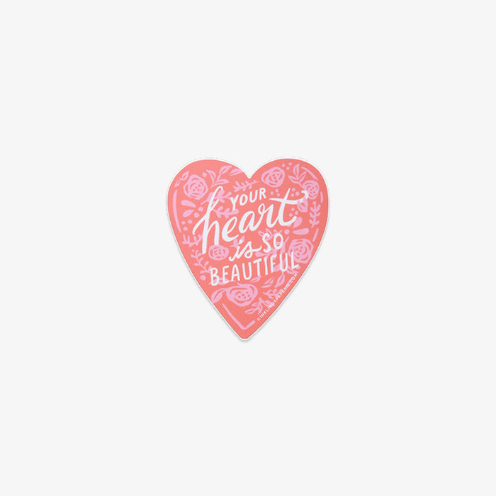 Heart-shaped pink vinyl sticker with text 'Your heart is so beautiful' on a white background