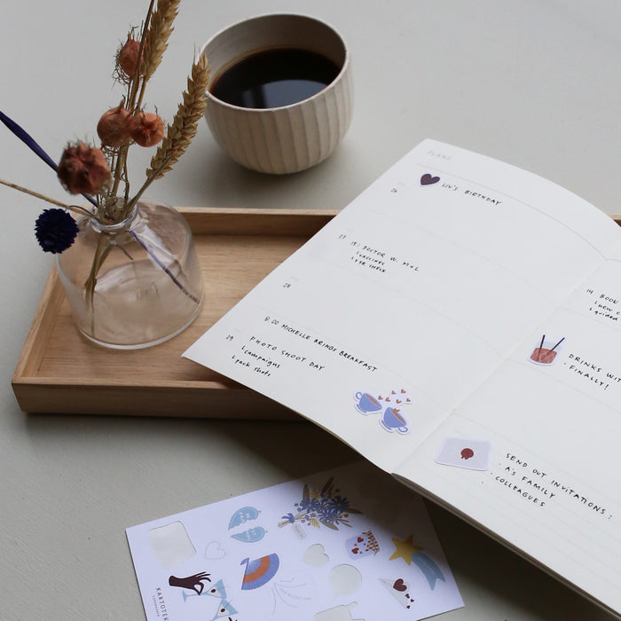 Table set up with the Weekly Planner notebook with examples of how to use it.