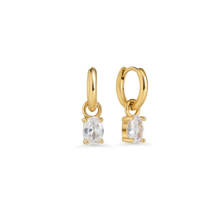 Gold hoop earrings with an oval clear stone pendant in a prong setting on a white background. Jewelry by Mia Bijoux Canada.

Boucles d'oreilles anneaux dorées avec pendentif serti sur griffes d'une pierre transparente ovale sur fond blanc. Bijoux par Mia Bijoux Canada.